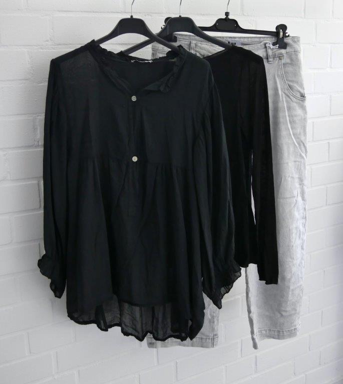 Graue Jeans mit schwarzem Longsleeve und schwarzer transparenter Bluse auf einem Bügel hängend