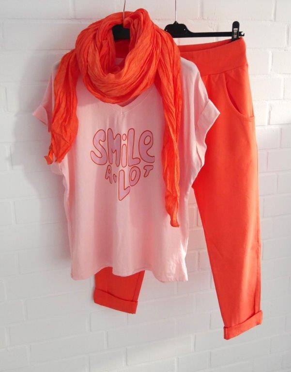Orangefarbene Jogger mit lachsfarbenem T-Shirt und passendem Schal in orange